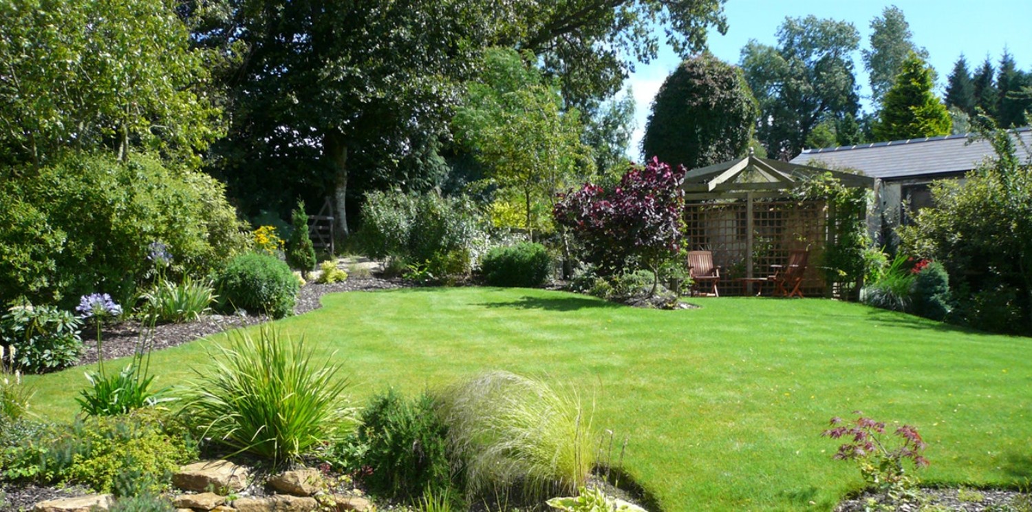 Finished Plantscapes Éireann garden with patio, lawn, planting, and clean outdoor structure